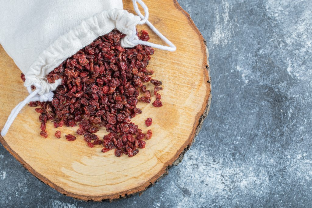 A wooden board full of dried cranberries